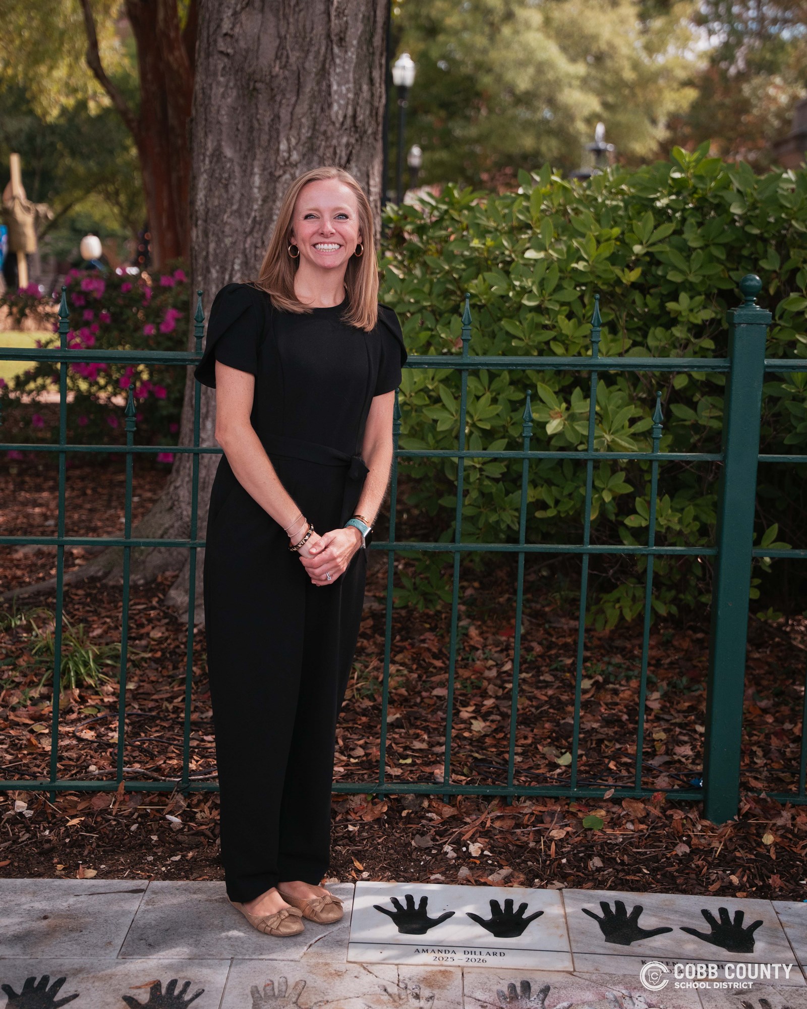 Amanda Dillard standing next to handprints