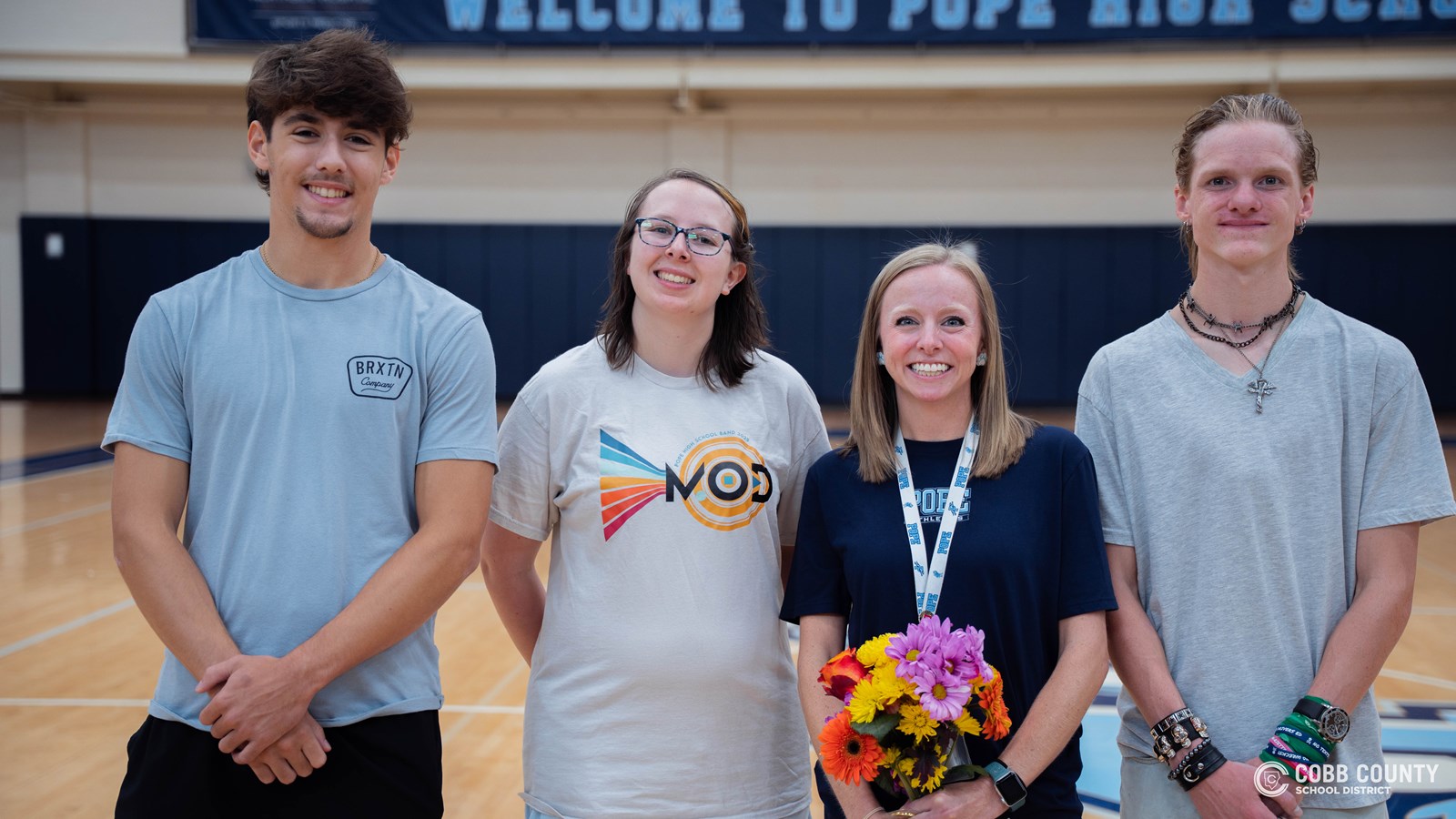 Cobb Schools Teacher of the Year Amanda Dillard smiles alongside two of her students, who proudly share how her guidance and encouragement have made a lasting difference in their lives.