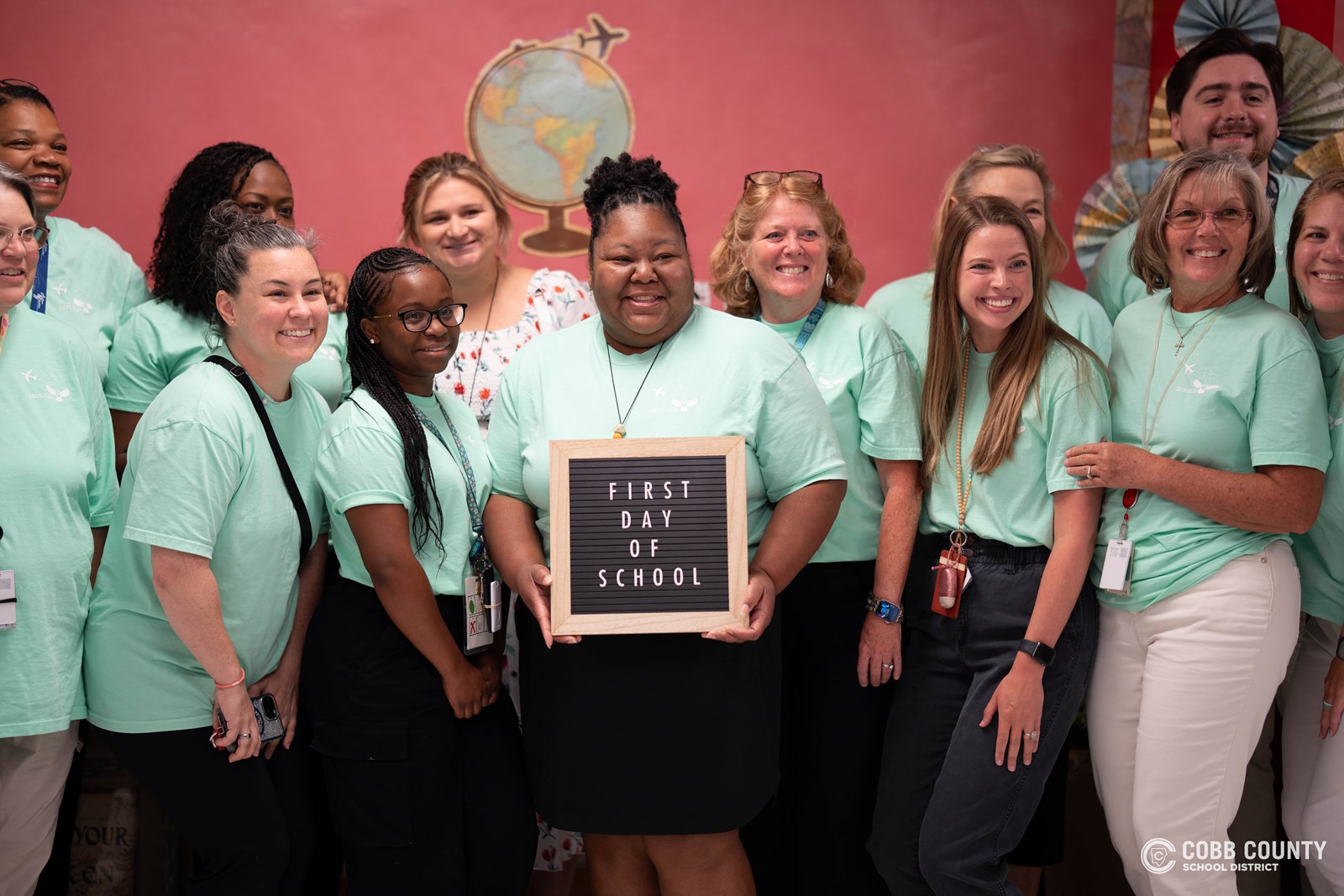 ChatGPT said: Hollydale Elementary staff smile with excitement as they gear up to welcome students on the first day of school, ready to make it a year full of learning and growth.