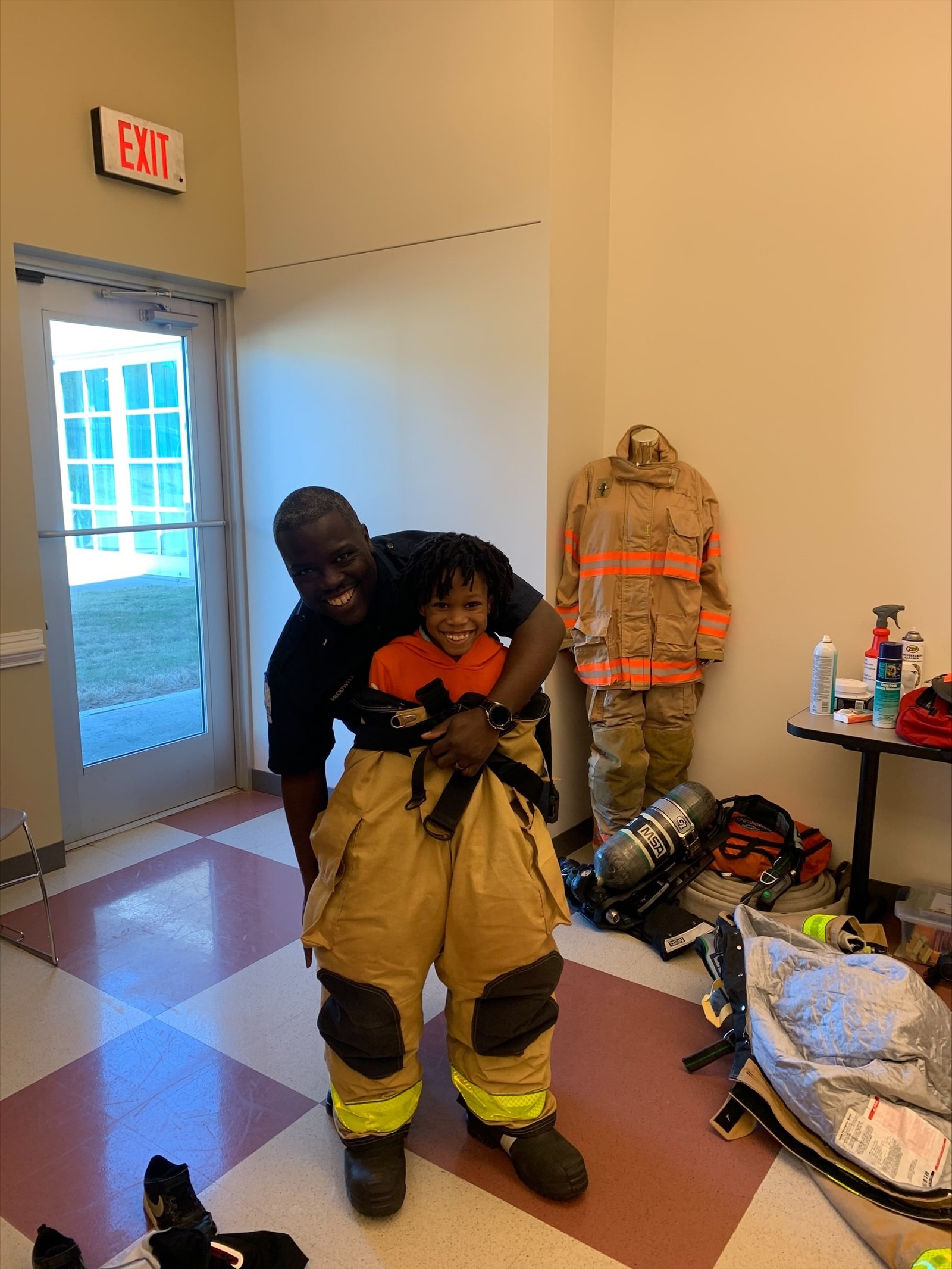 boy trying on firefighter gear