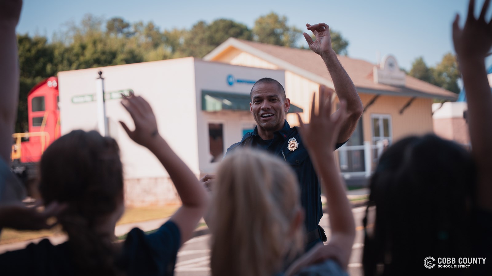 Students raise hands during Cobb Safety Village field trip