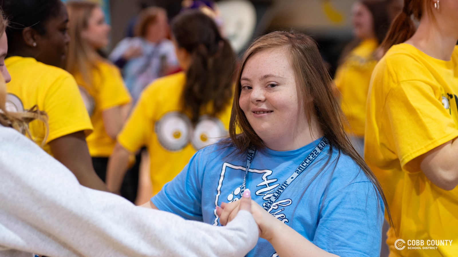 A student embraces every moment of fun and celebration with a big smile at Kennesaw Mountain High School’s annual dance for students with special needs!