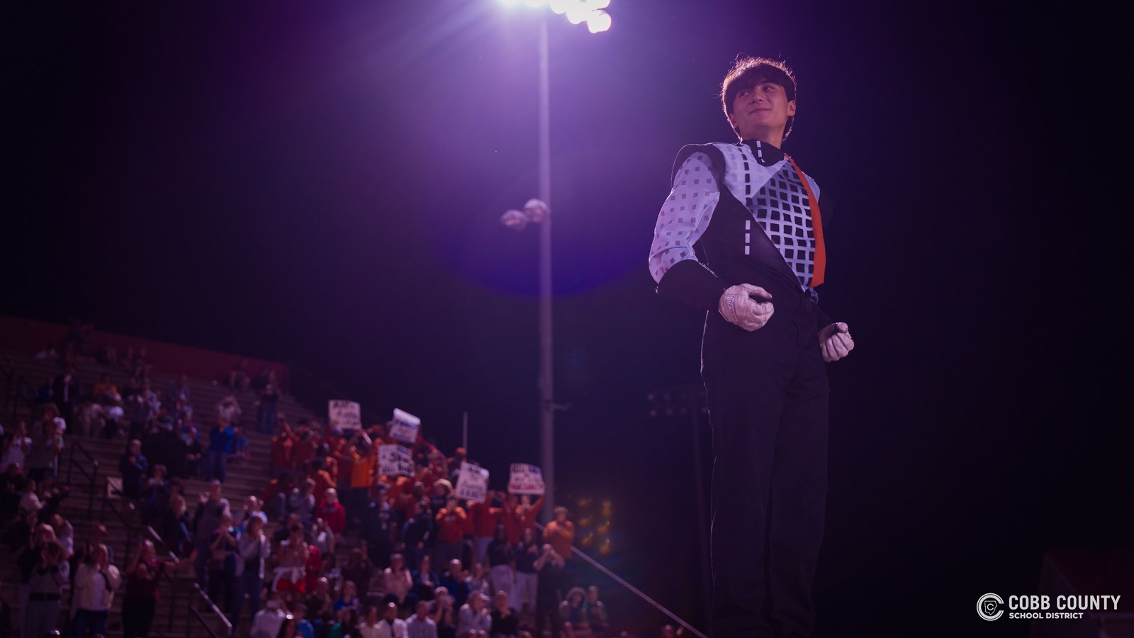 The Kell Marching Band Drum Major hears support from the football team in the background