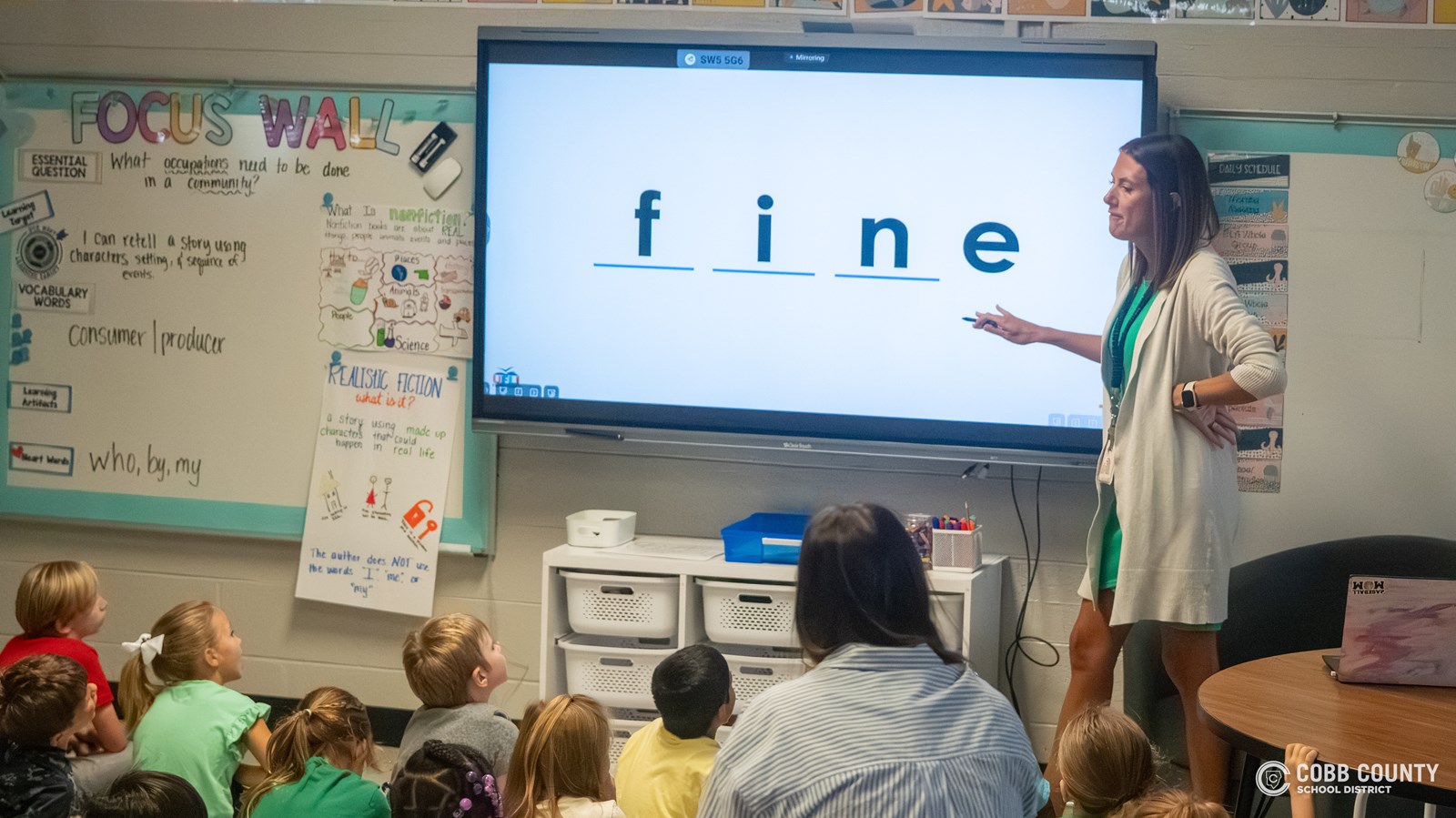 Mrs. Johnson teaching at the smart board in her classroom.