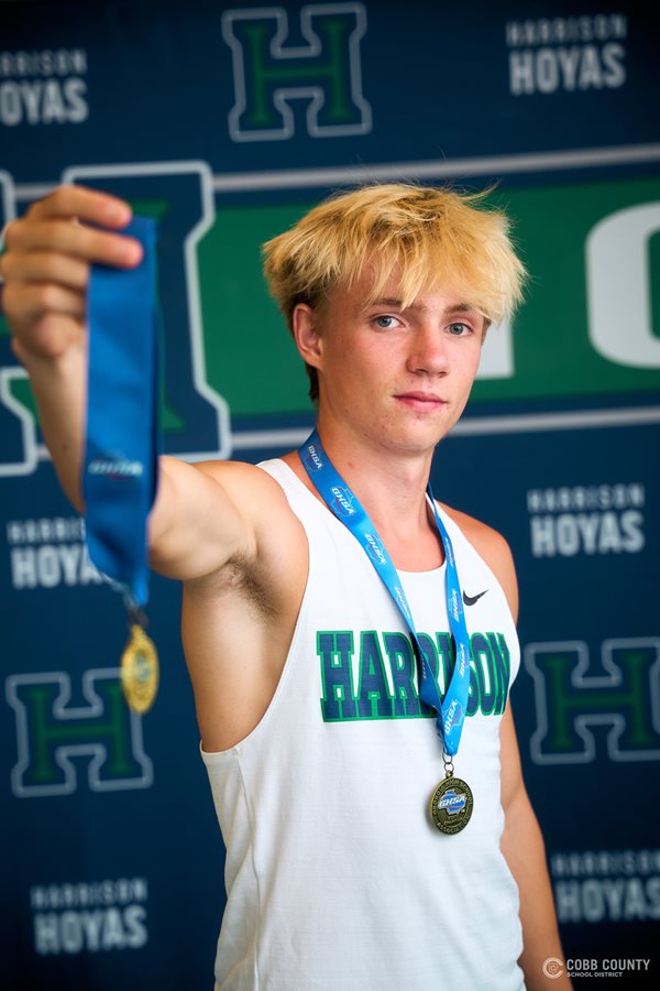 Harrison's Riley Comstock shows off some of his race medals