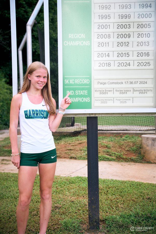 Harrison's Paige Comstock points out her 5K record and State Championship