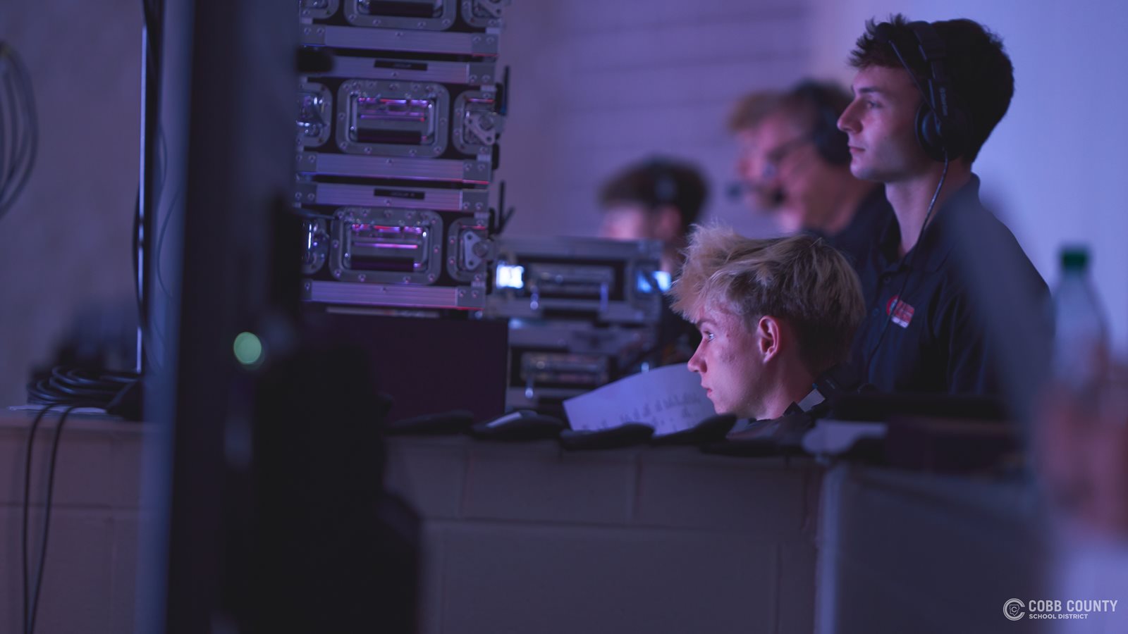 Riley Comstock keeps track of audio levels during a live event