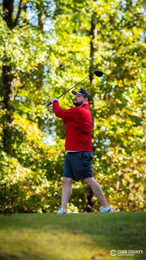 A golfer watches his tee shot