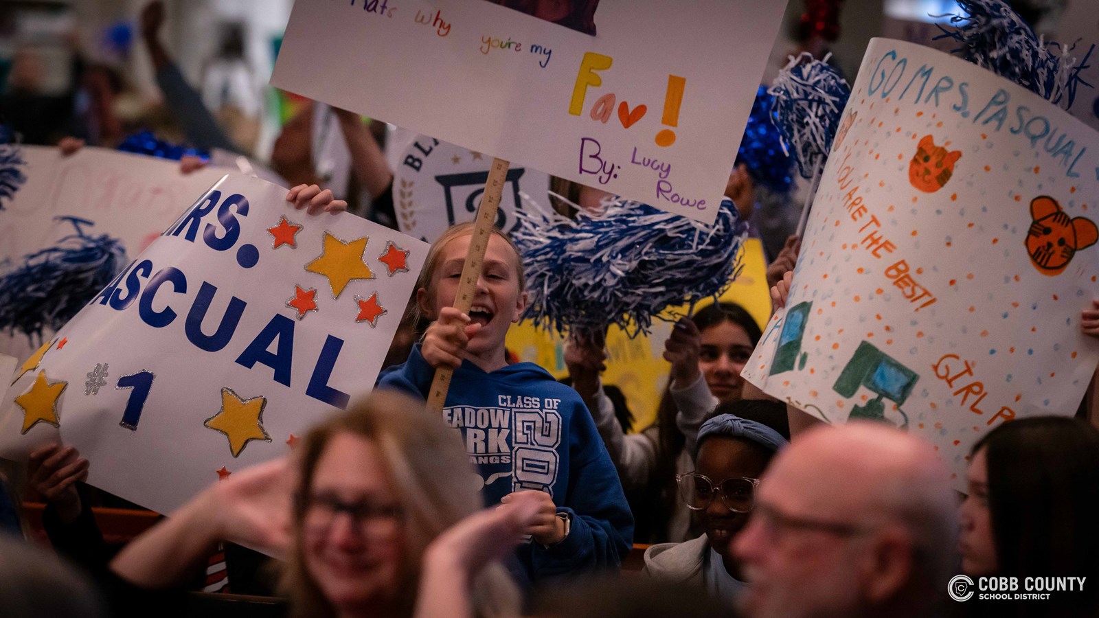 Students holding signs and cheering