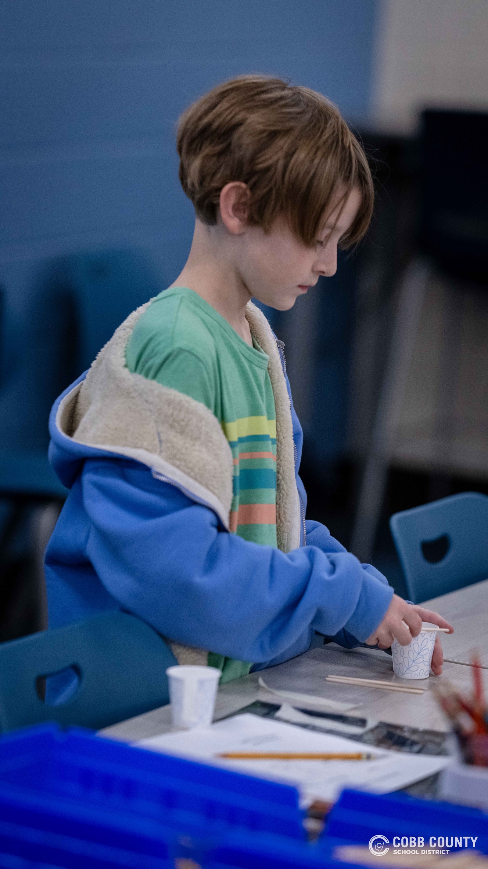 Crowds of students, families, and alumni explore decade-themed displays at Dodgen Middle School’s 50th anniversary STEM Showcase.