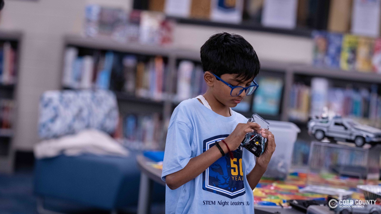 Crowds of students, families, and alumni explore decade-themed displays at Dodgen Middle School’s 50th anniversary STEM Showcase.