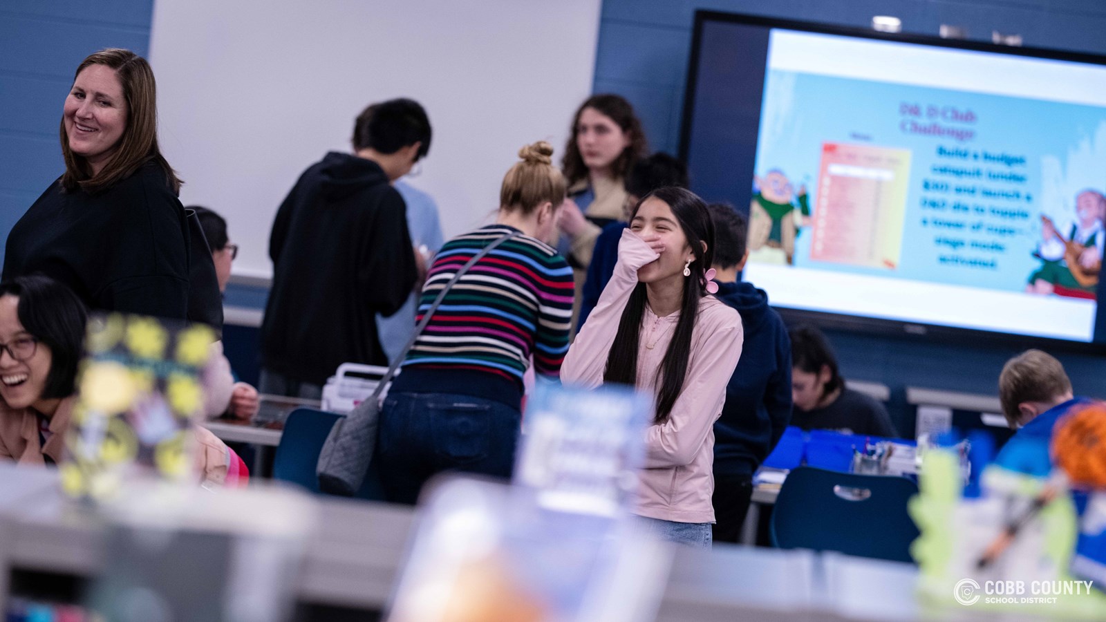 Crowds of students, families, and alumni explore decade-themed displays at Dodgen Middle School’s 50th anniversary STEM Showcase.