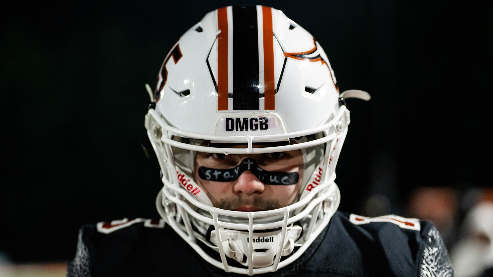 A Kell player stares into camera with their DMGB acronym showing on his helmet