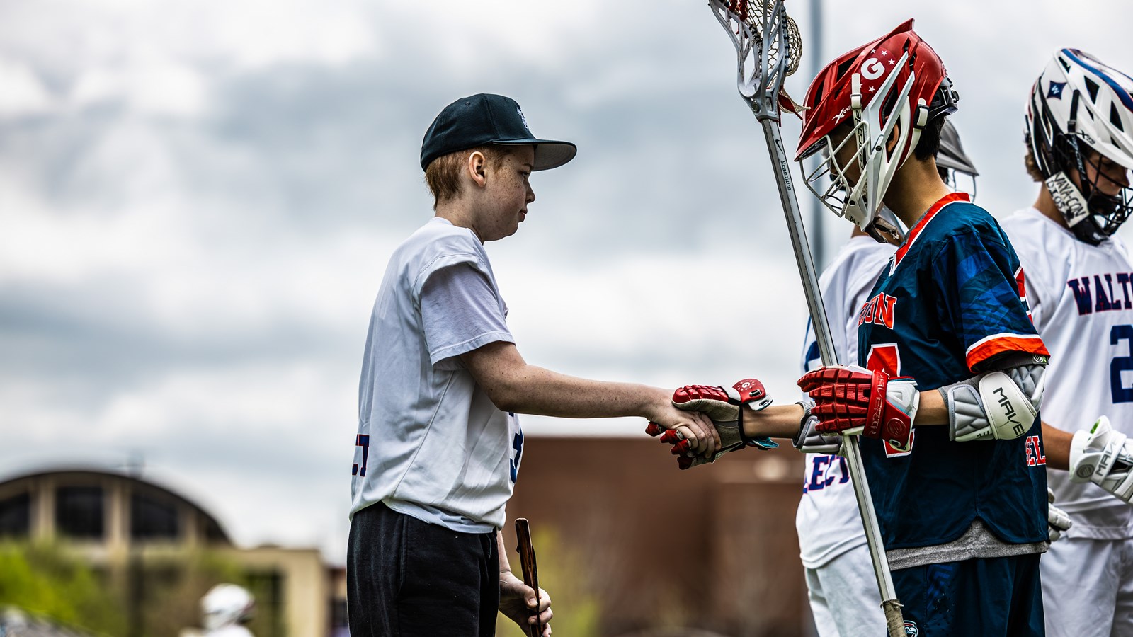 Jackson Jefcoat shakes hands with a Milton HS captain before the coin flip
