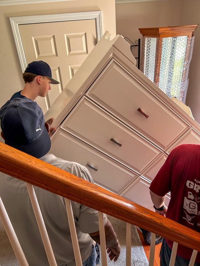 Harrison football players move a dresser for Mr. Randall