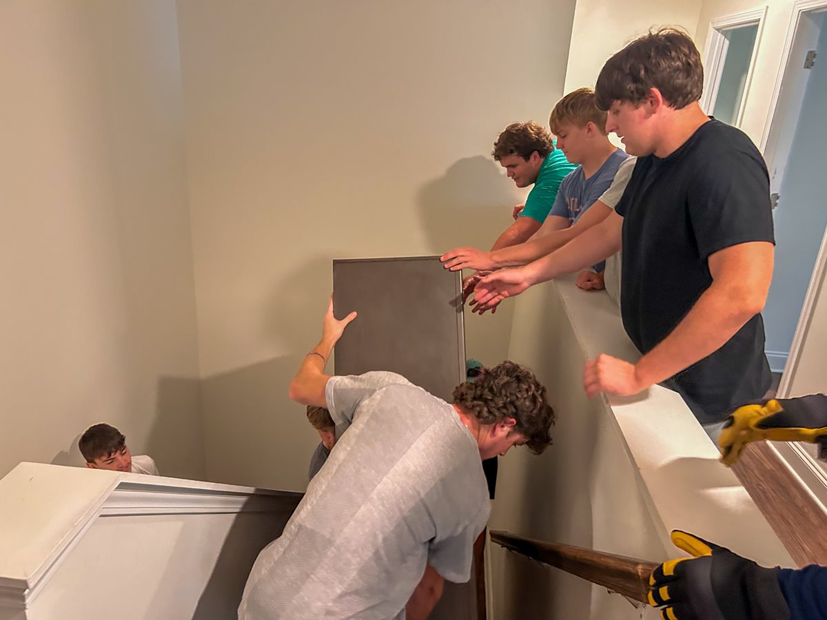 Harrison football players move furniture