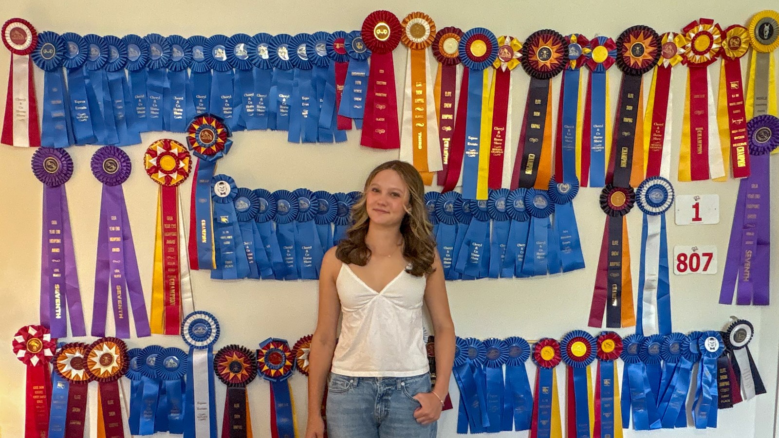 Anna poses in front of her Ribbon Wall at home