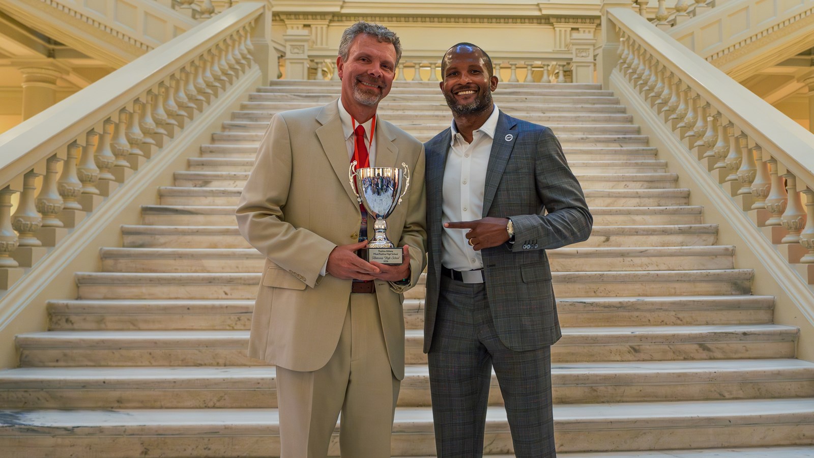 Allatoona Athletic Director Christopher Murray accepts the trophy for the Most Positive High School in Georgia from Champ Bailey