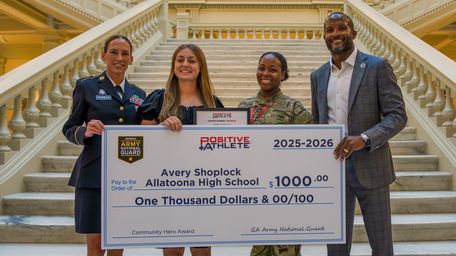 Allatoona's Avery Shoplock holds up the scholarship check for winning the Positive Athlete Georgia Army National Guard Community Hero Award