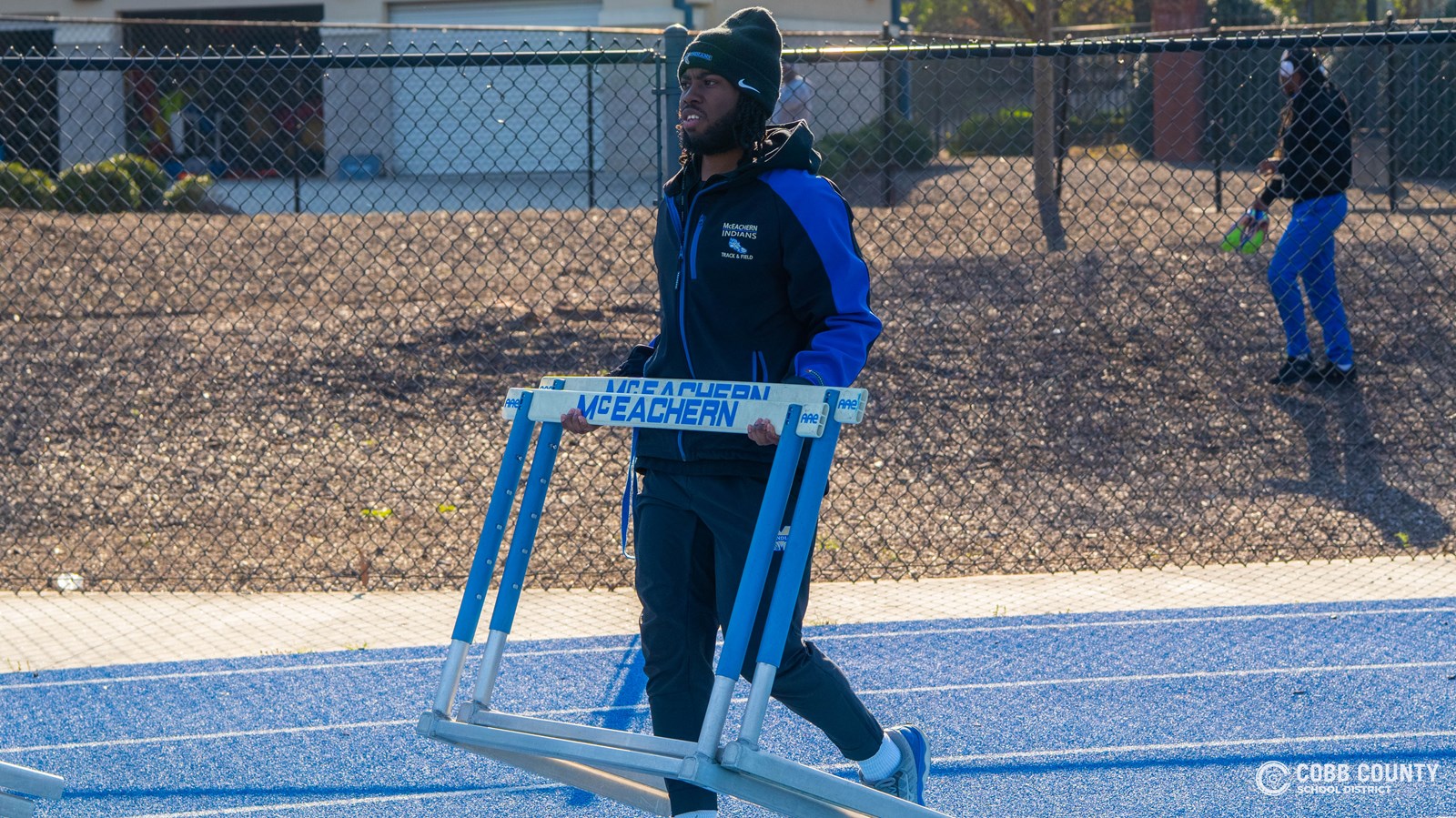 Coach Talton brings out hurdles for a track meet