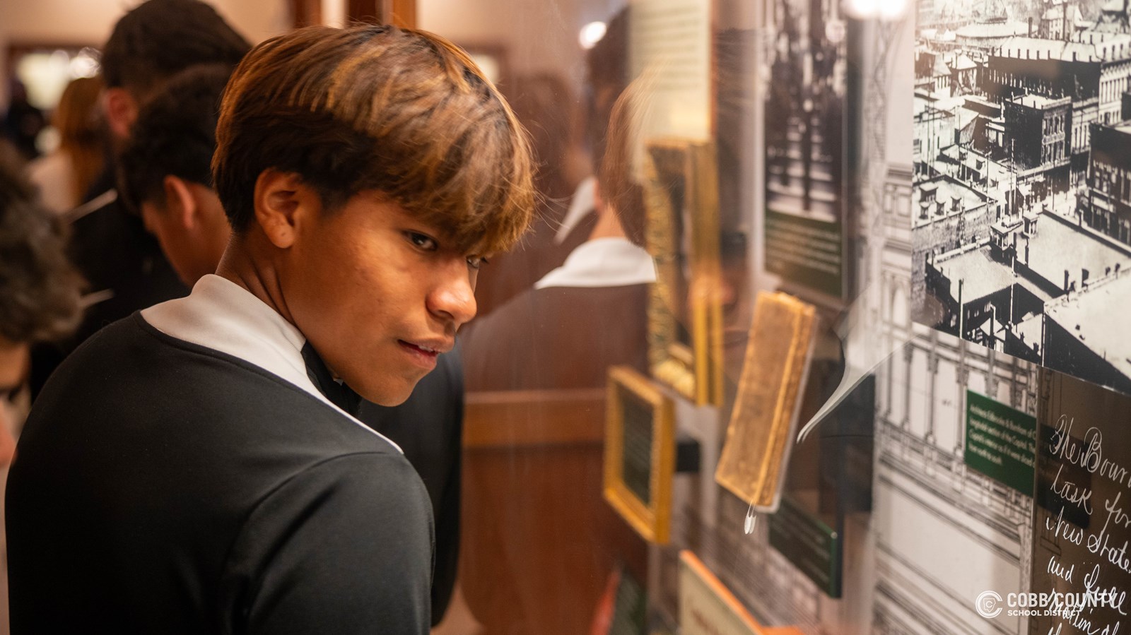A Campbell soccer player checks out museum artifacts displayed outside of the Senate Gallery