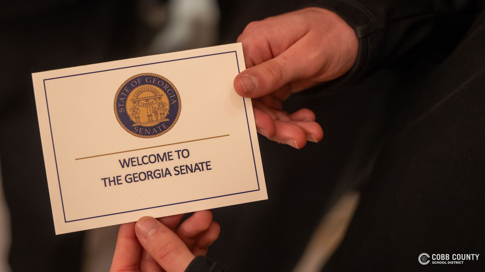A Campbell soccer player holds an official welcome card