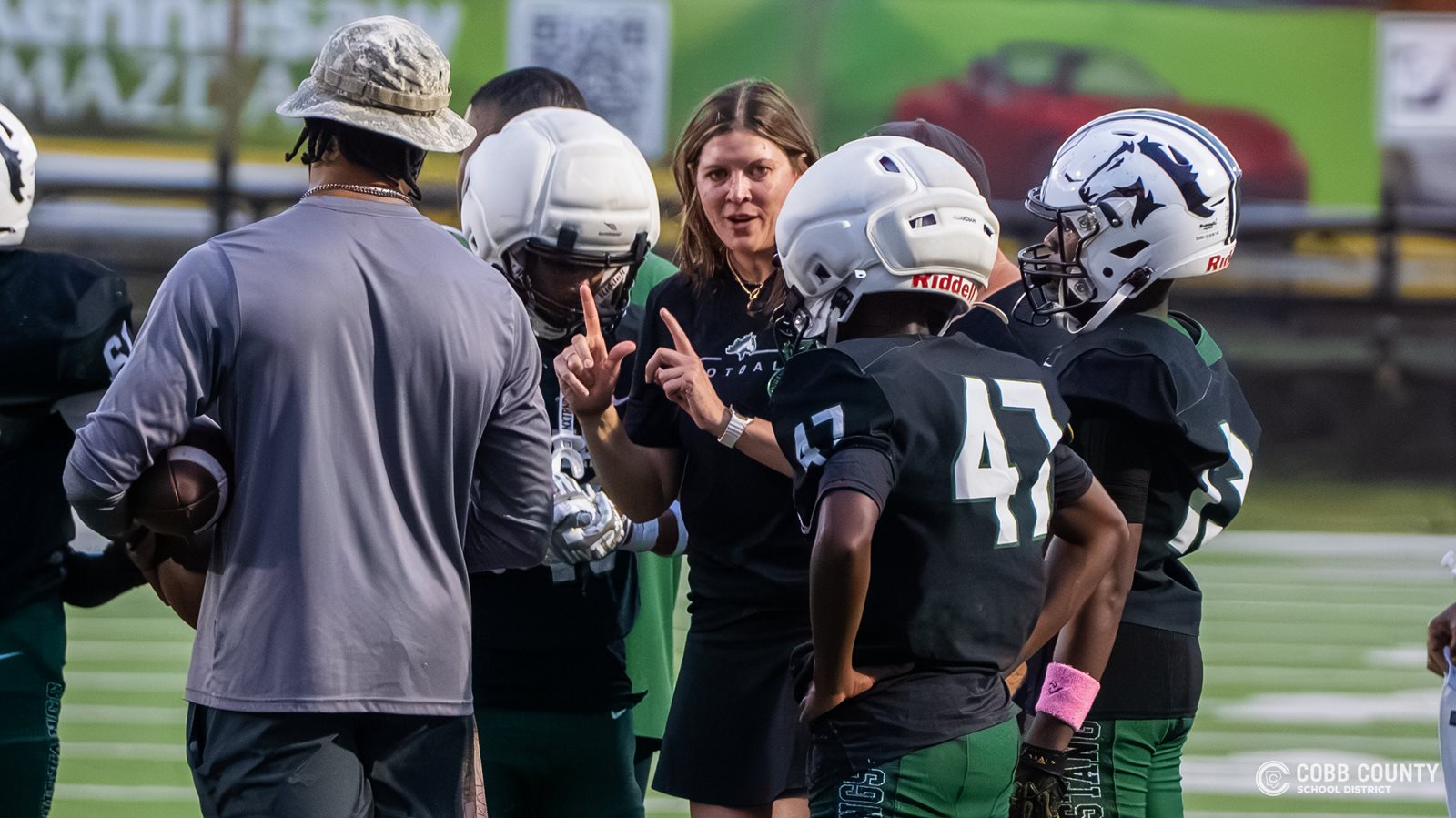 Coach Jarvis interprets for Larenzo Parker during a timeout