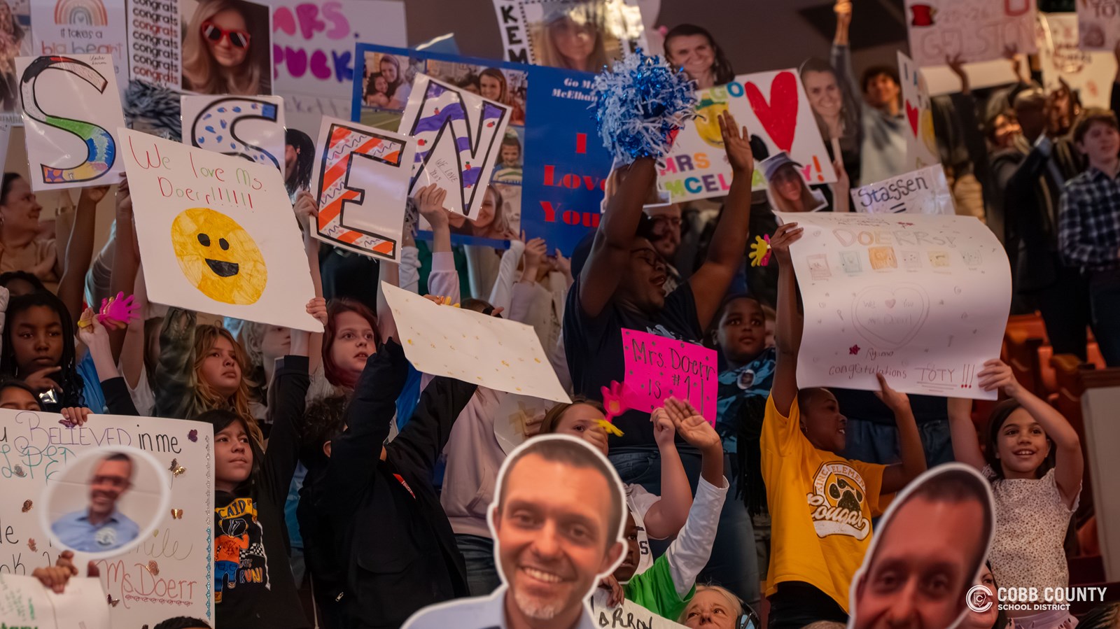 Crowd cheering and holding signs