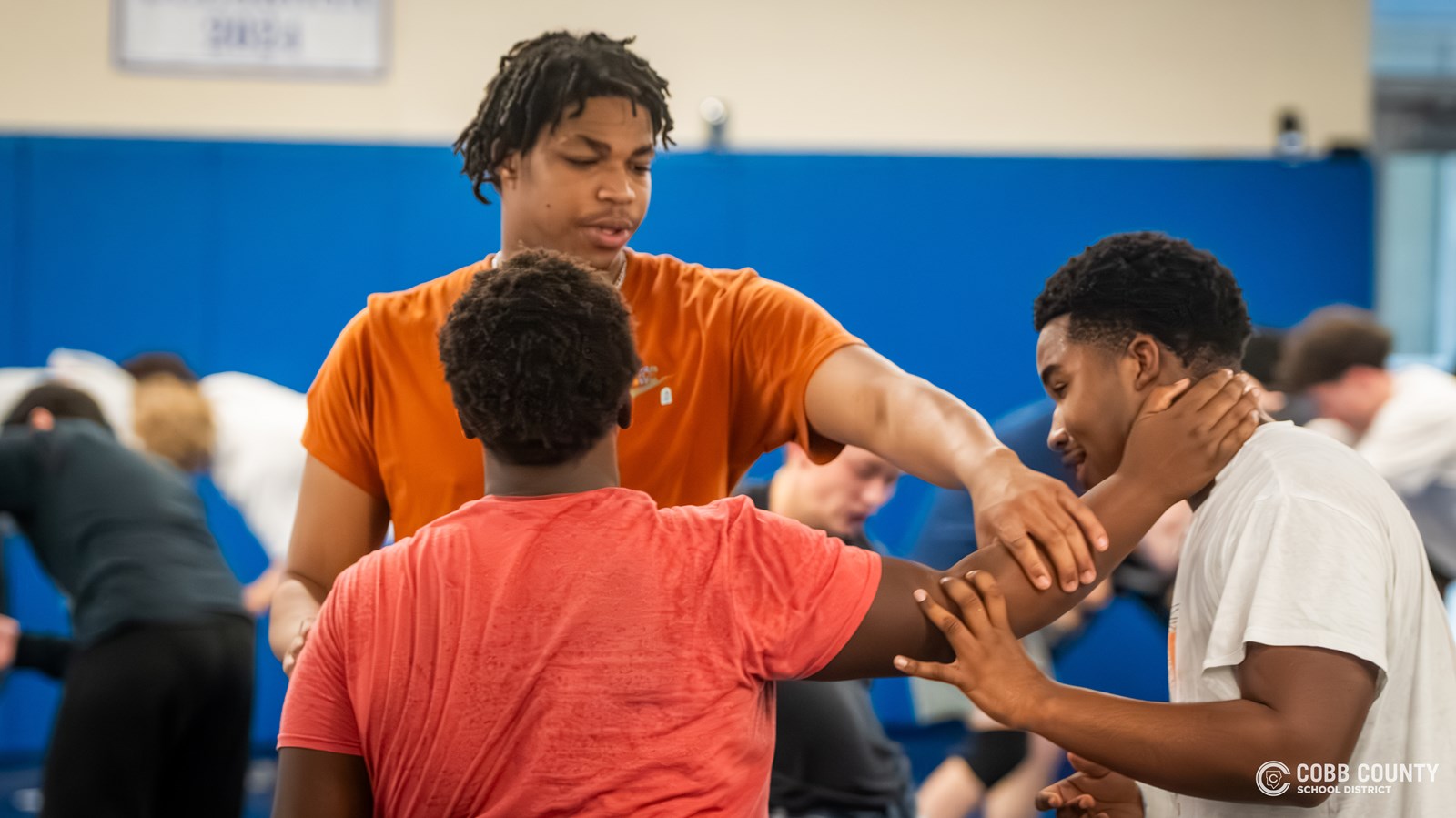 Bin gives pointers to his wrestling teammates
