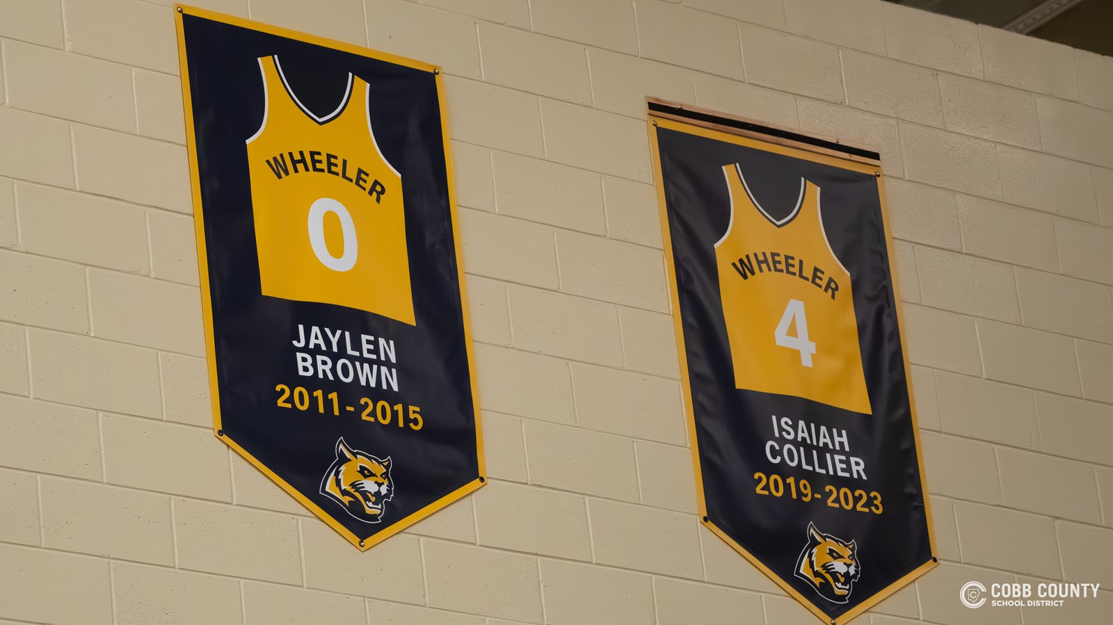 Isaiah Collier's jersey banner hangs next to Jaylen Brown's