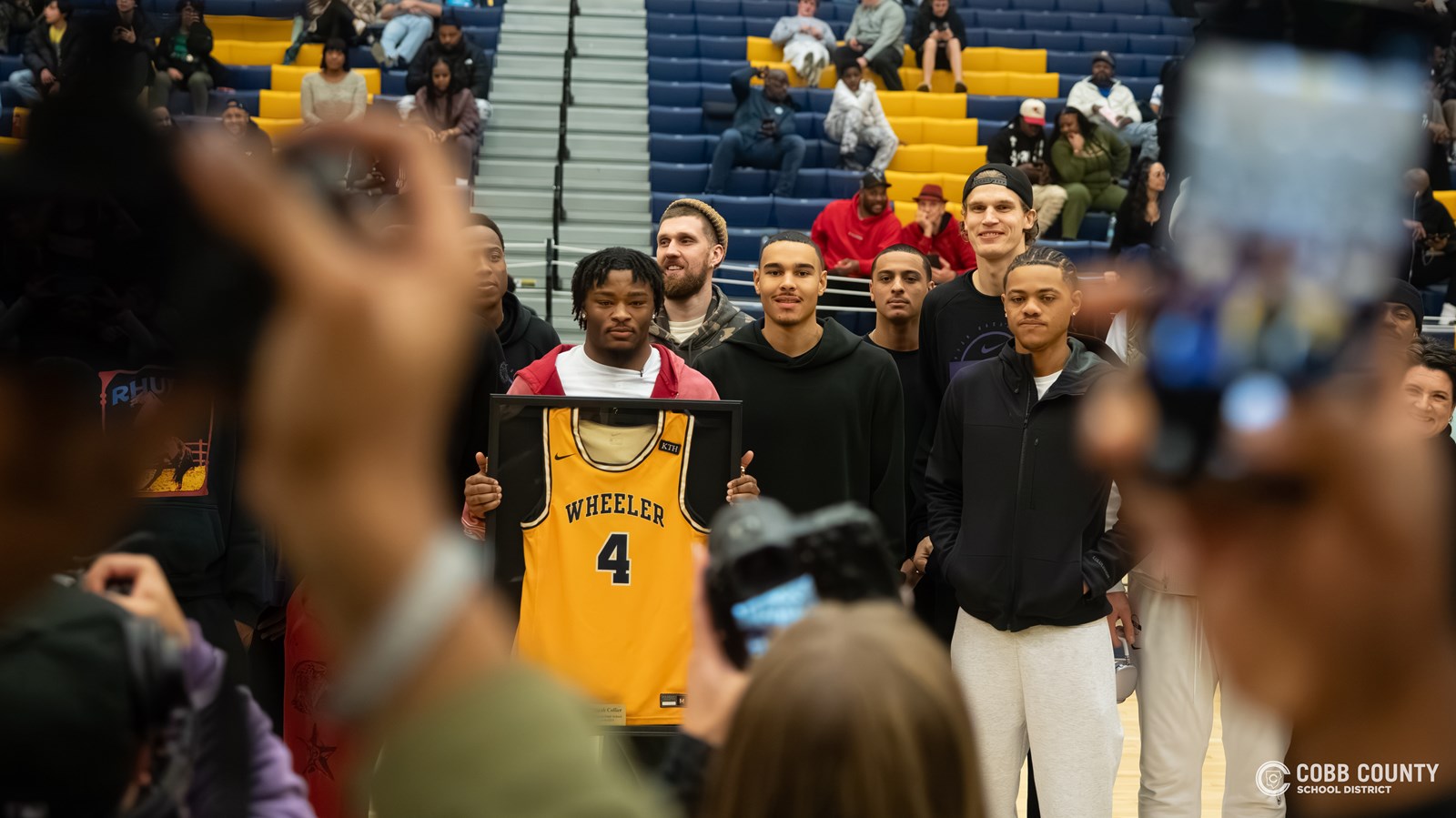 Collier poses for pictures surrounded by his Jazz teammates