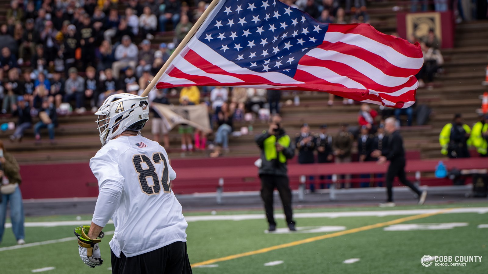 Army's Sean Byrne runs the field with the American flag