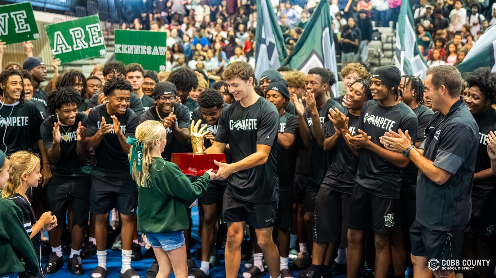 The KMHS football team accepts the trophy