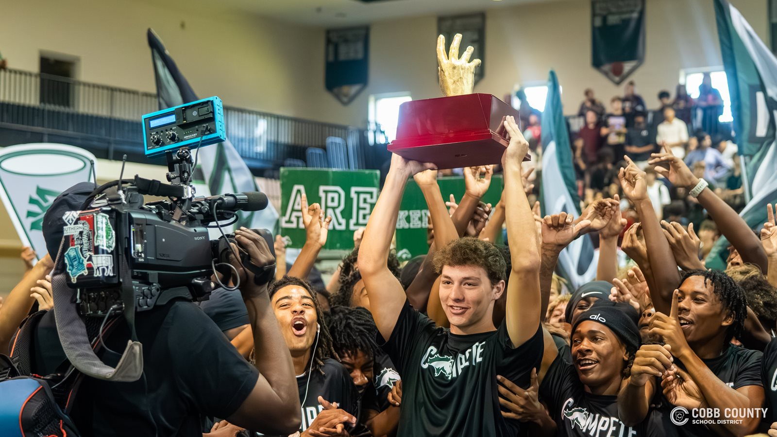The KMHS football team lifts the trophy high
