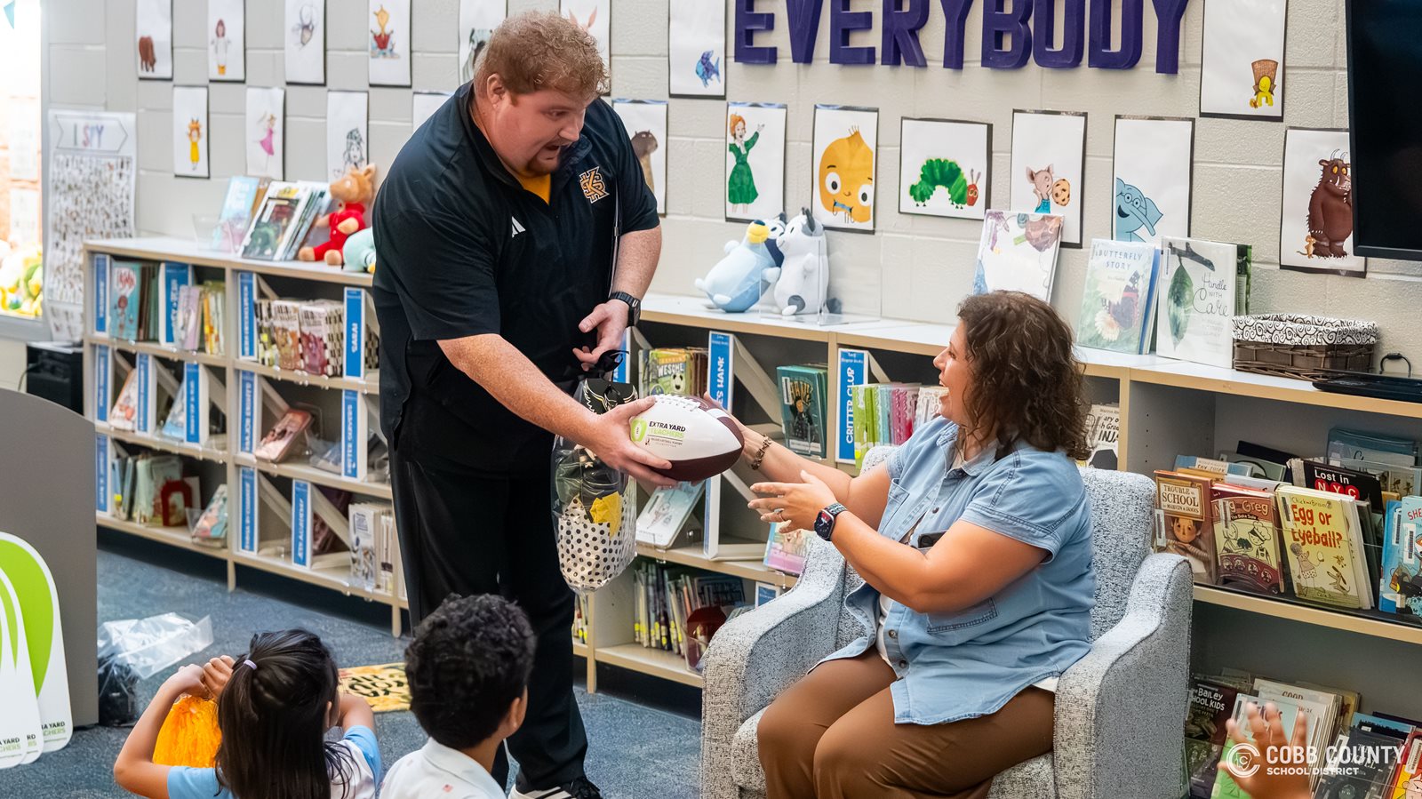 KSU Assistant Athletic Director Jacob Dye presents Mrs. Eubanks with a commemorative game ball