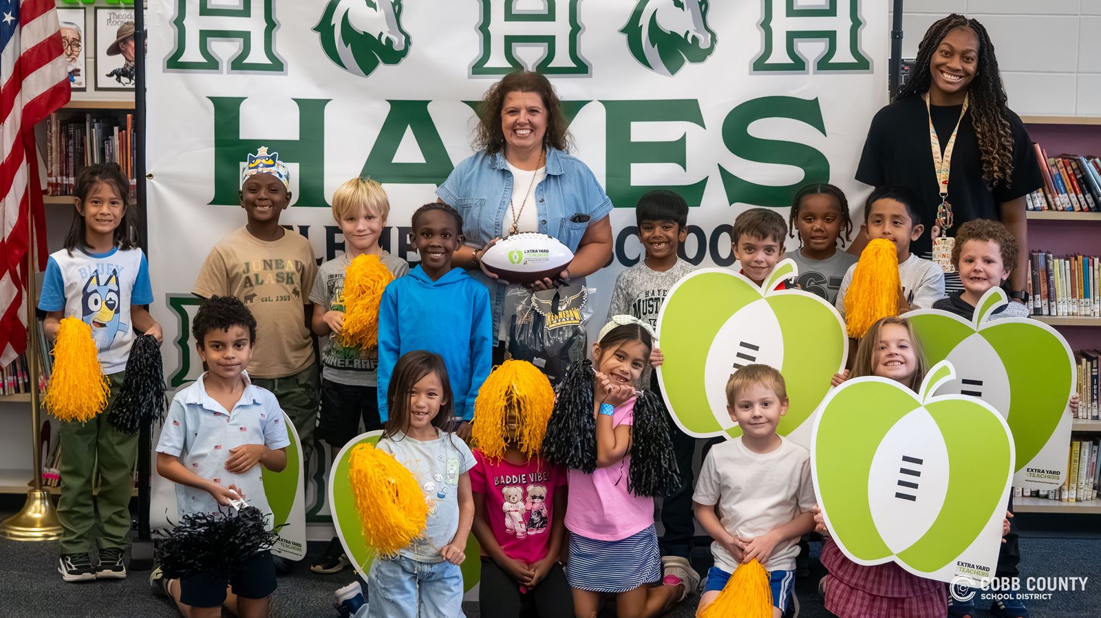 Mrs. Eubanks and student teacher Olivia Burrage pose with their first-grade students