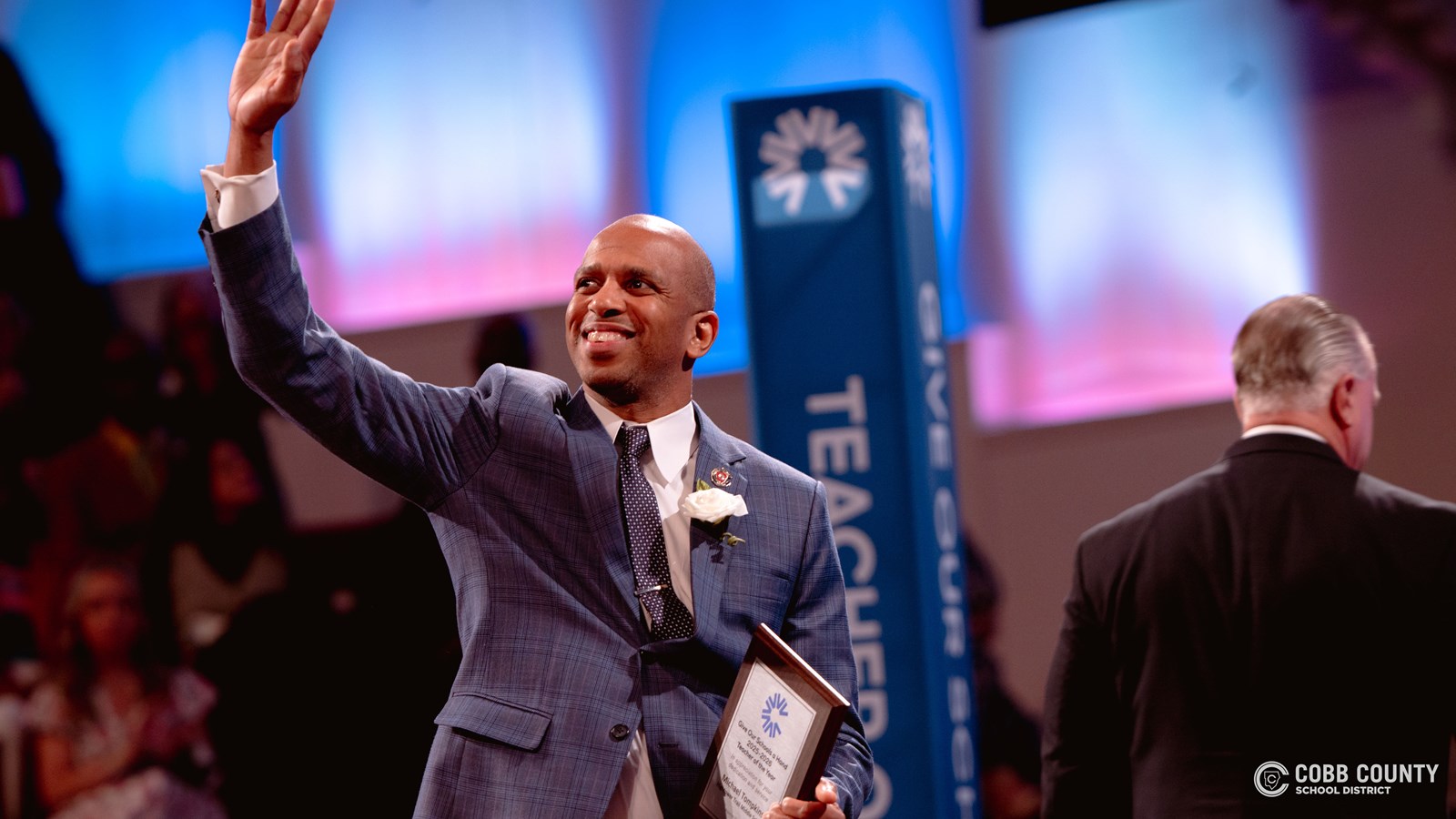 Teacher waving on stage