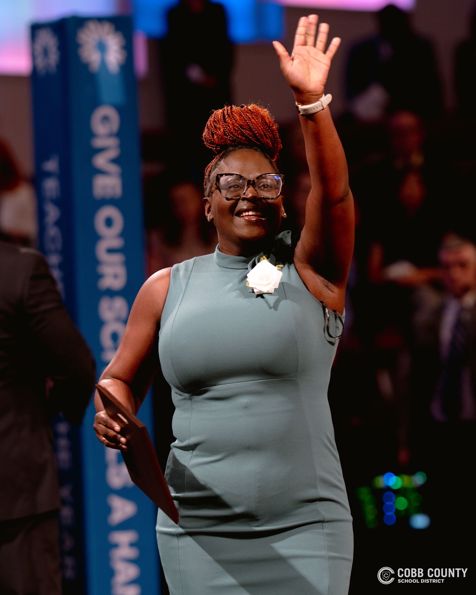 Teacher waving on stage