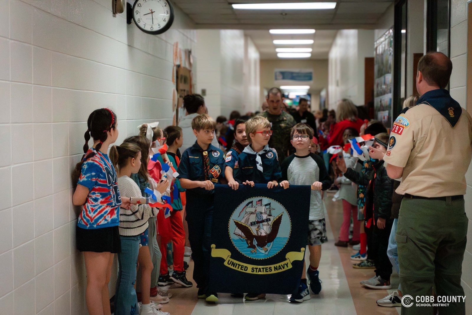 Boy Scout holding United States Navy banner