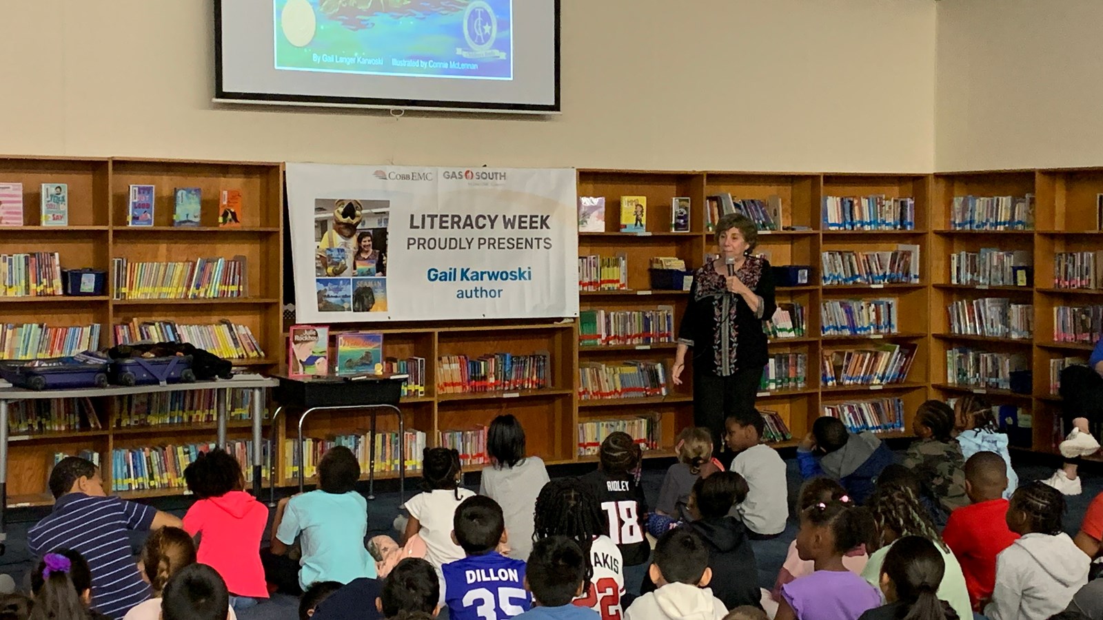 Author standing in front of students talking