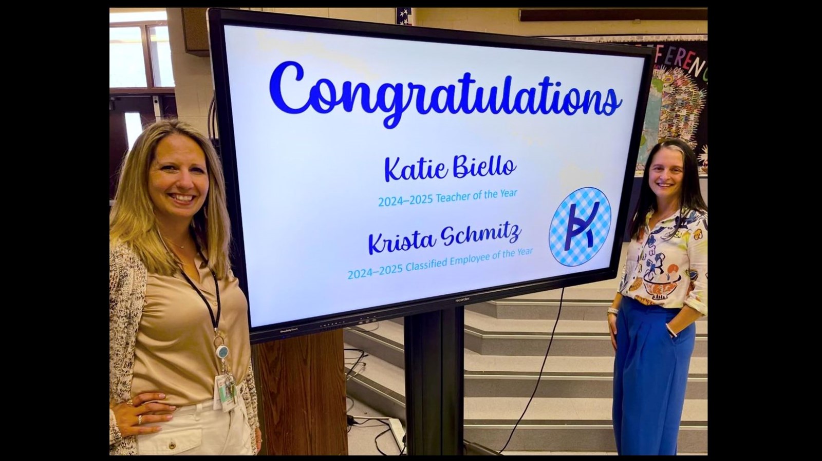 Large screen with Krista Schmitz and Katie Biello, Congratulations Katie Biello, 2024-2025 Teacher of the Year and Krista Schmitz, 2024-2025 Classified Employee of the Year