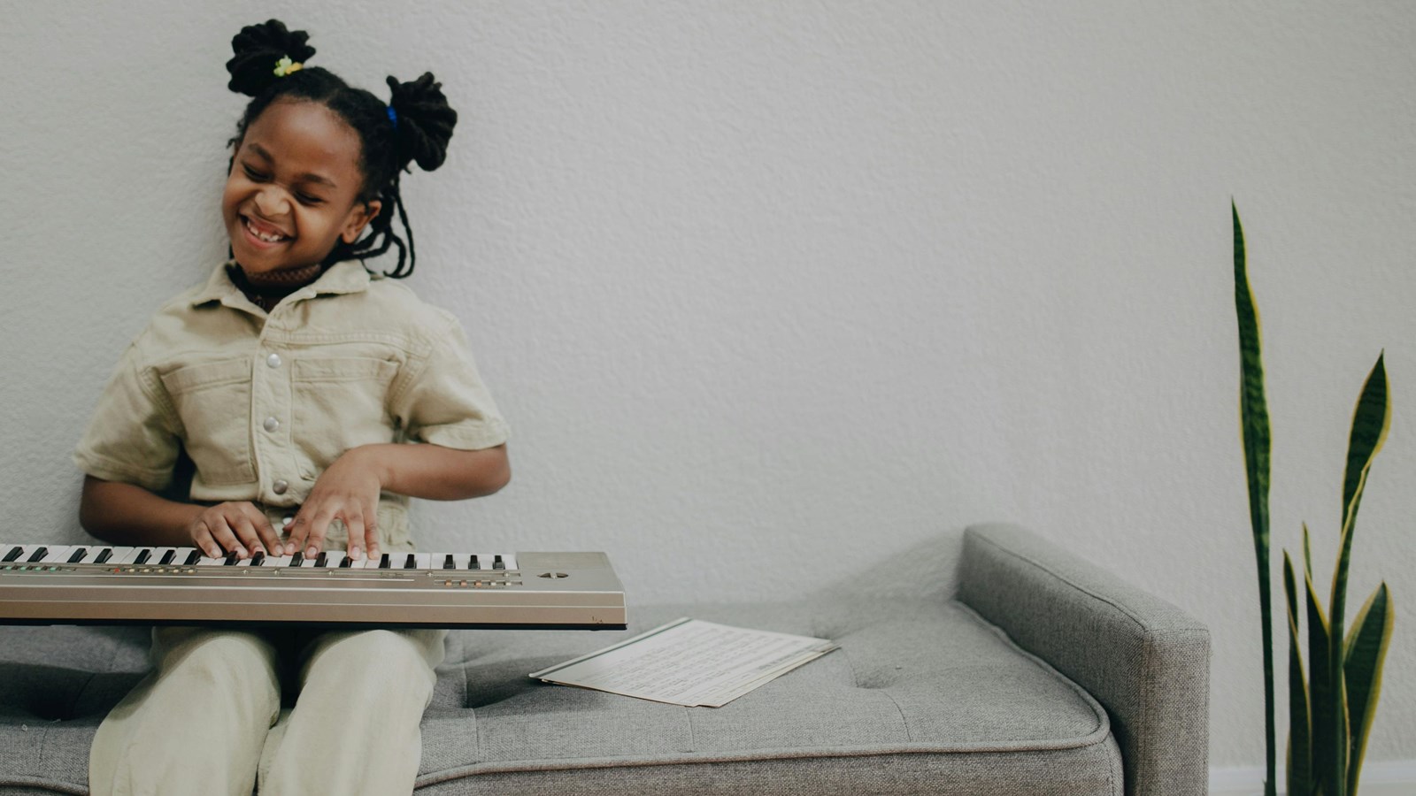 student sitting on a bench playing on a piano keyboard