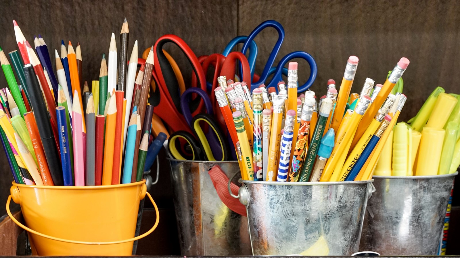 pencils and highlighters in metal buckets