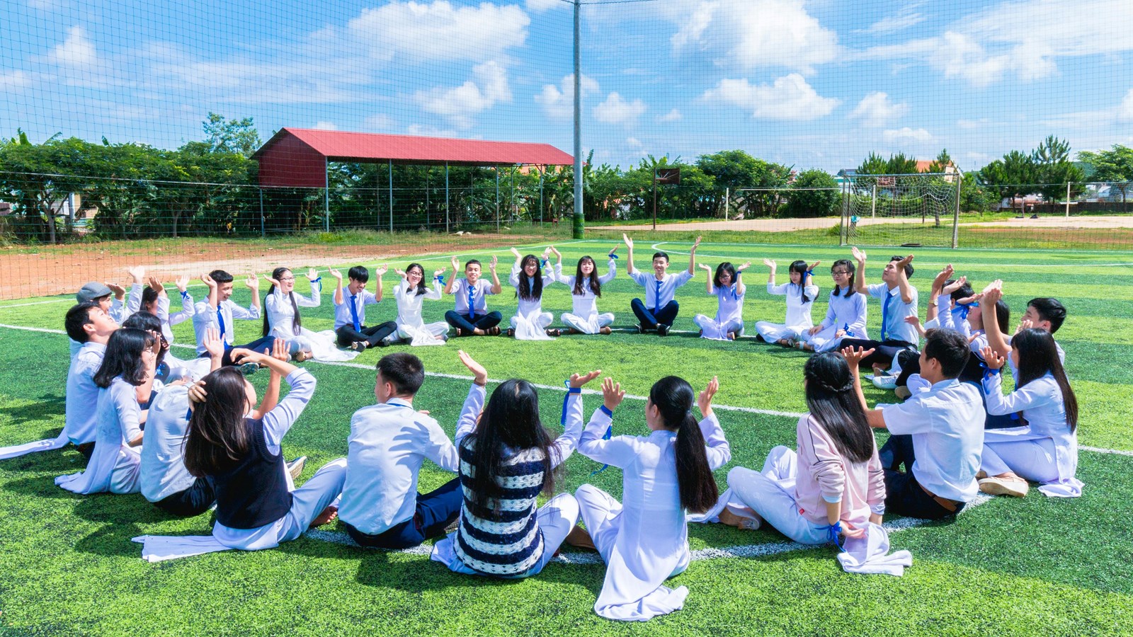 students sitting in a circle on a field